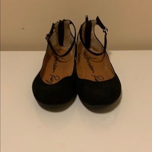 Black flats with ankle strap.